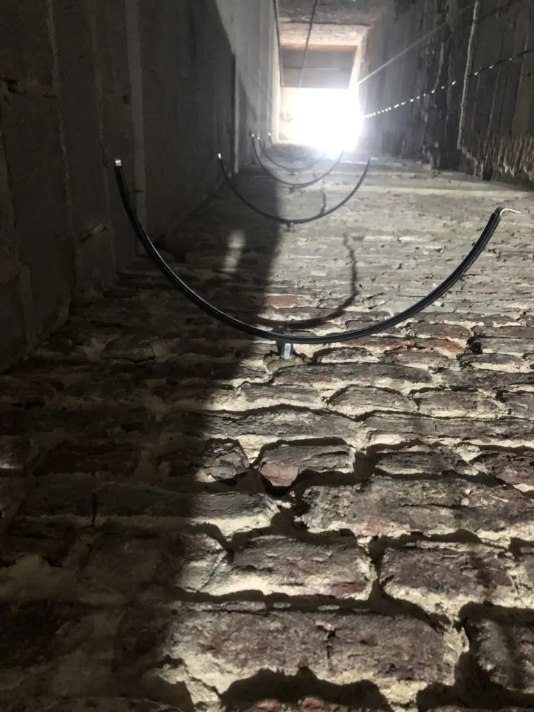 Des supports en demi-cercle fixés sur la maçonnerie en brique de la gaine, avant la pose du conduit