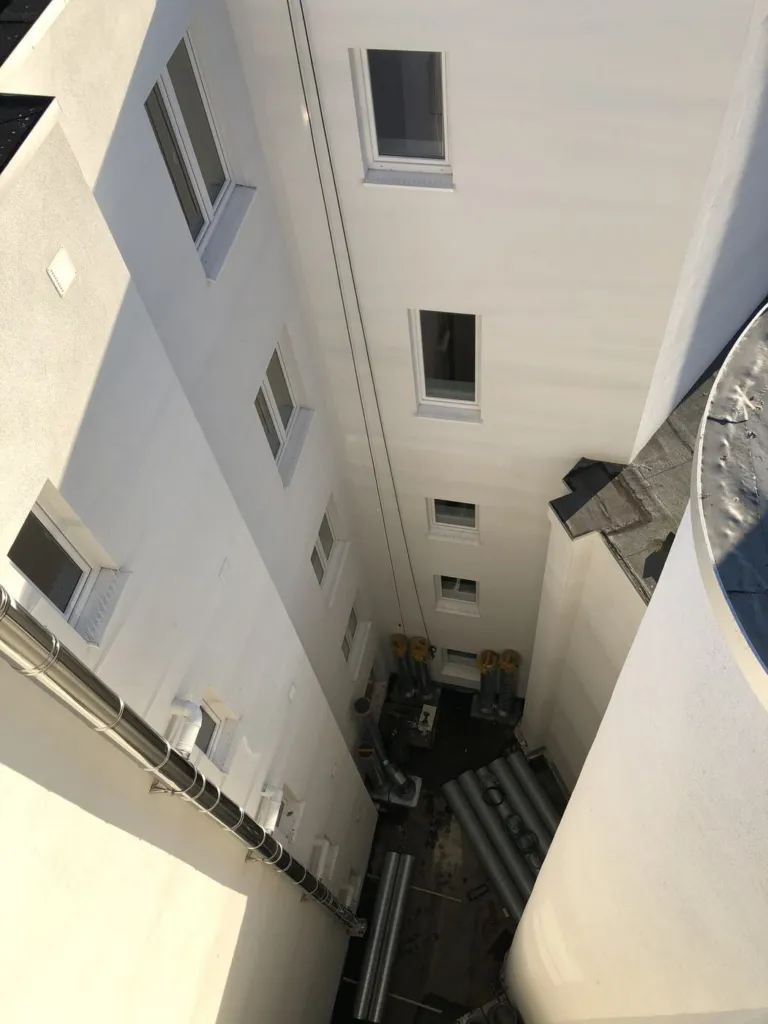 La cour intérieure vue depuis la toiture avant la pose, les premiers éléments de conduits au sol et en partie basse