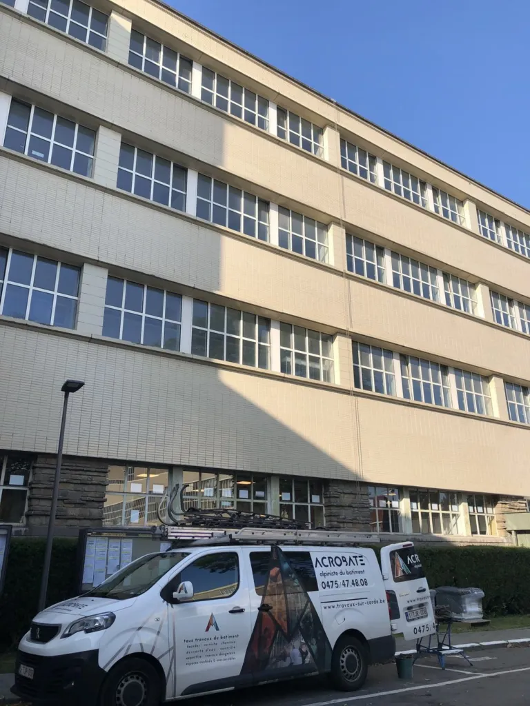 La façade du bâtiment du CERIA avant la pose des conduits, la camionnette Acrobate garée au pied