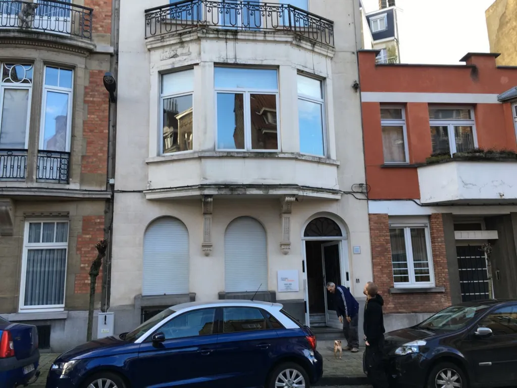 La façade avant travaux : enduit gris et taché, bow-window et balcon en fer forgé dans leur état initial