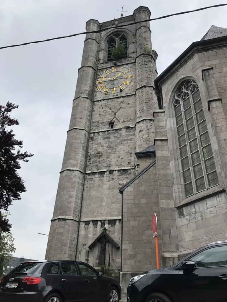 La tour en pierre de l'église et son horloge, vue depuis la rue