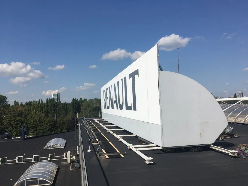 La toiture plate du bâtiment et l'enseigne Renault, lanterneaux en premier plan