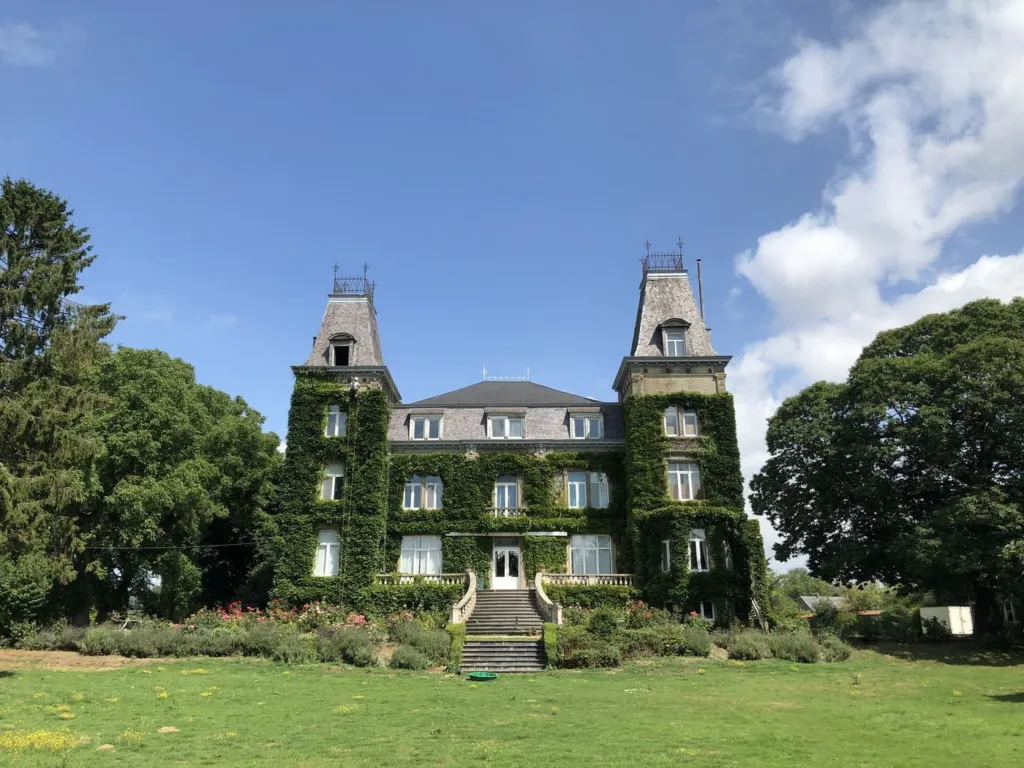 Château et ses deux tours, façade entièrement couverte de lierre, vu depuis le parc