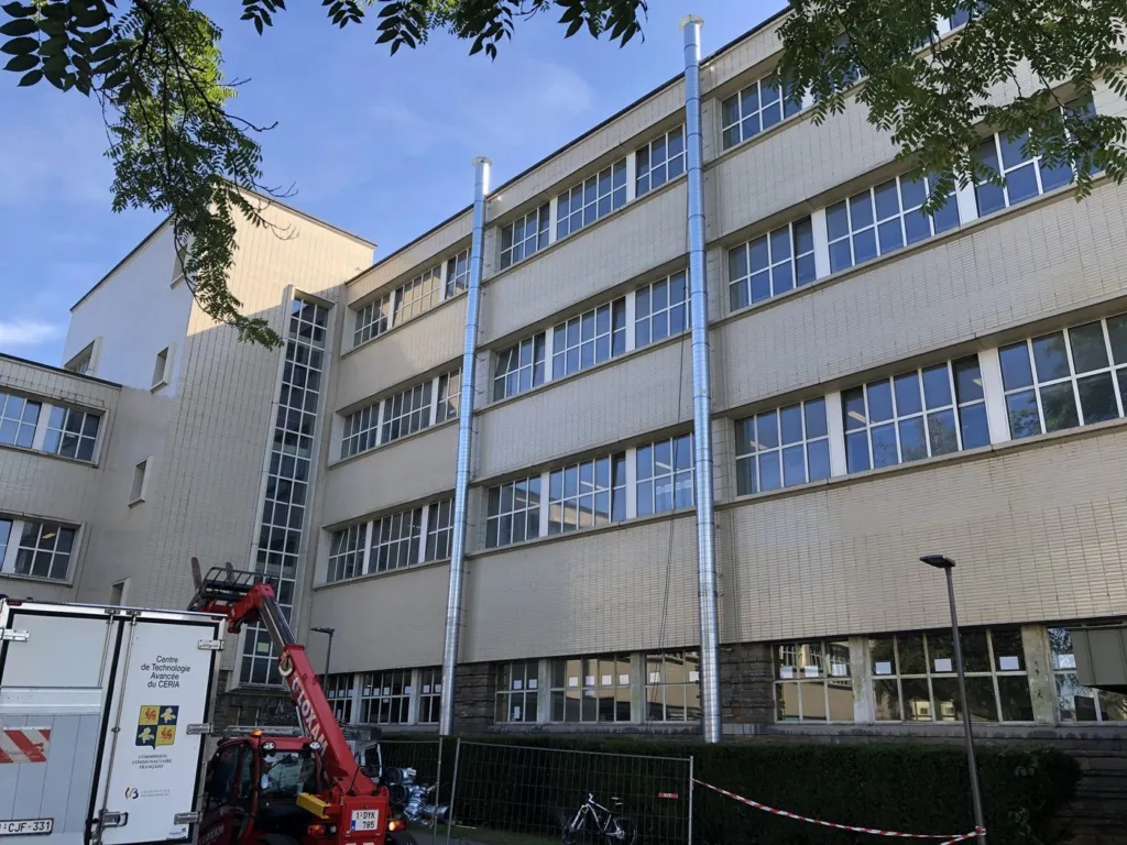 La façade avec les deux conduits d'aération posés du sol jusqu'au-dessus du toit, vue d'ensemble