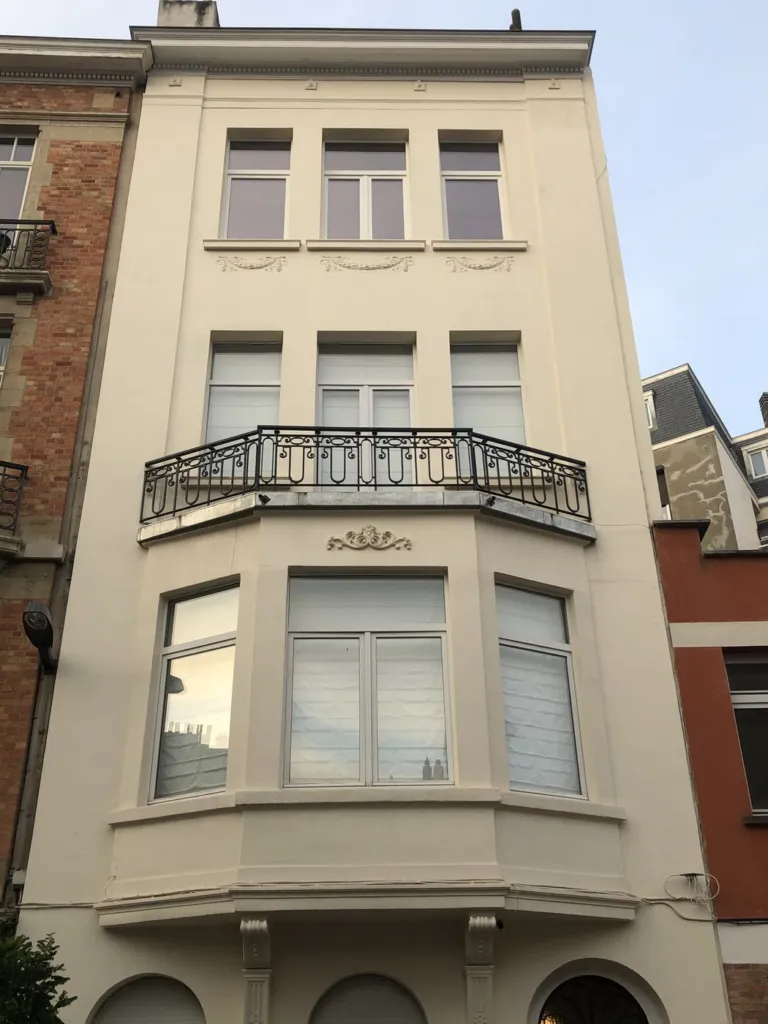 La façade restaurée vue depuis la rue, bow-window, balcon et ornements en finition claire