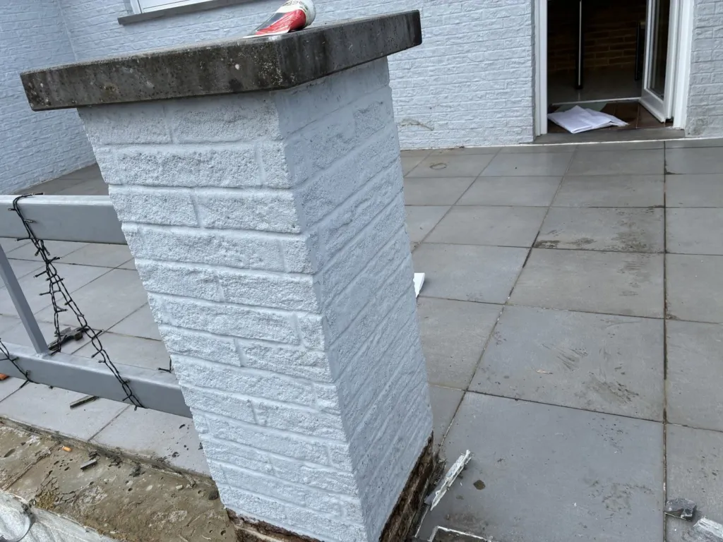 L'ancien carrelage gris et un pilier de la terrasse avant travaux