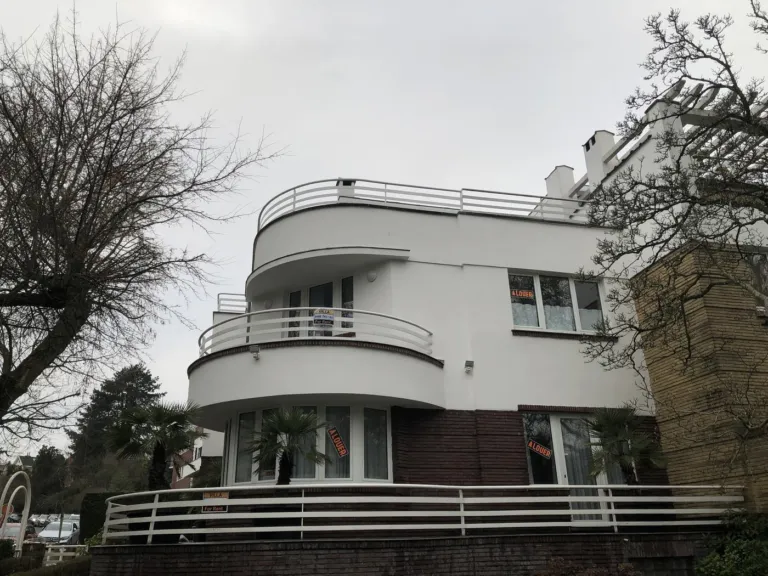 Un bâtiment blanc aux balcons arrondis après rénovation de ses façades