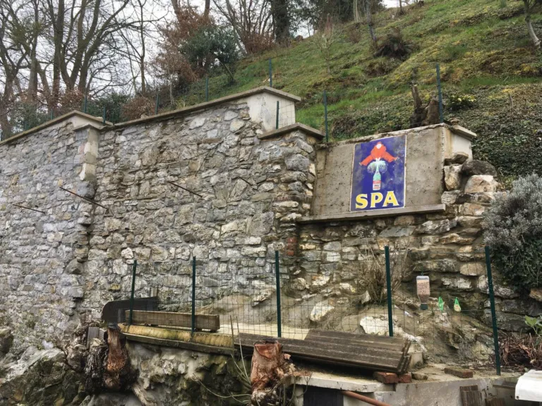 Le mur de soutènement restauré à Dinant, couronnements en béton, plaque émaillée conservée