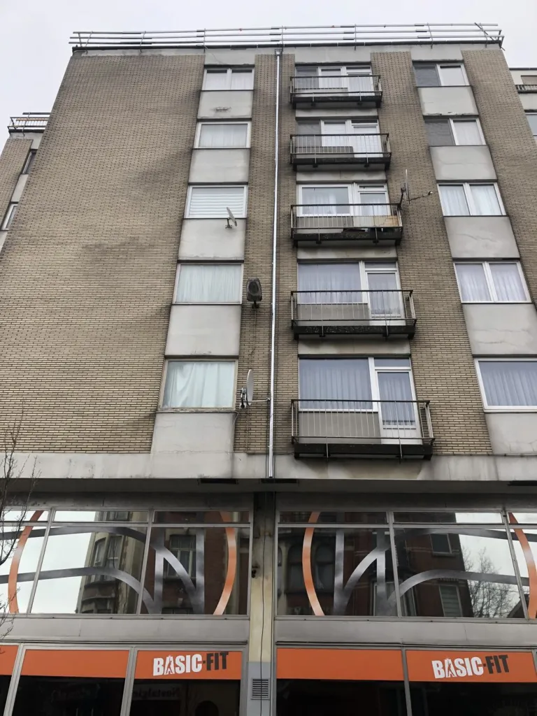 Descente d'eau posée le long de la façade d'un immeuble de sept niveaux