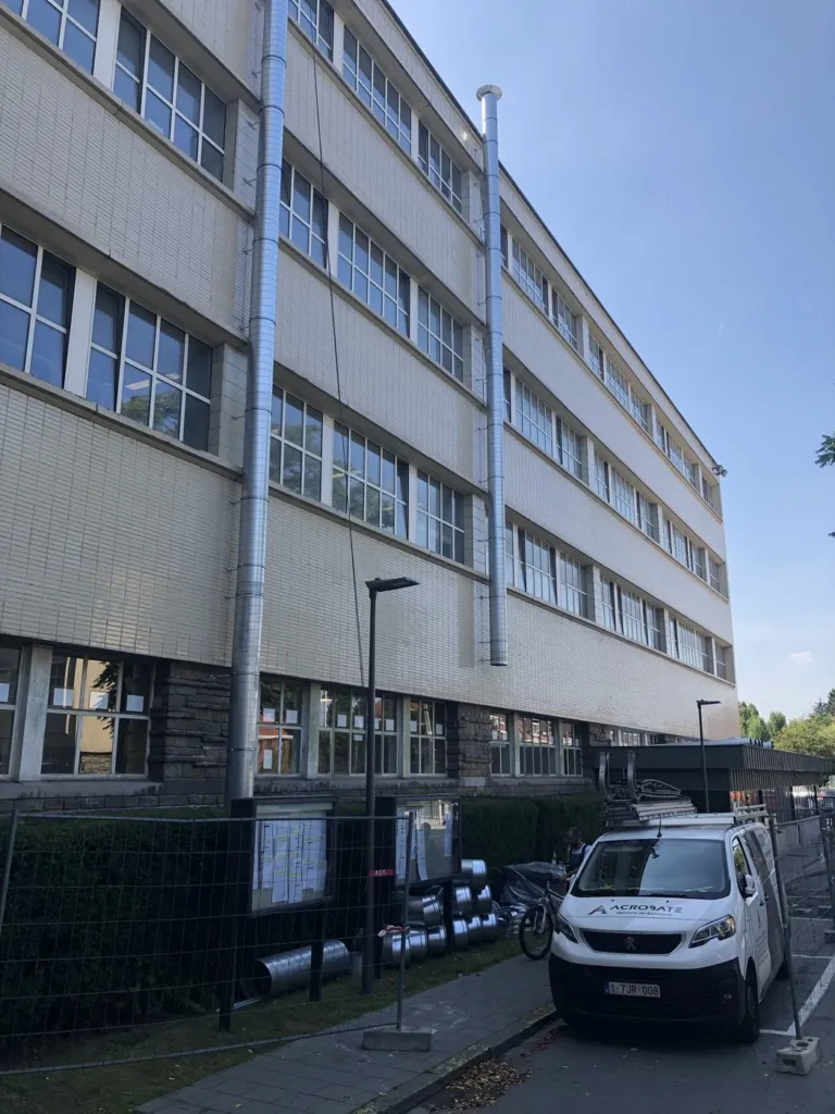 Deux conduits d'aération posés en façade d'un bâtiment du CERIA, à Anderlecht
