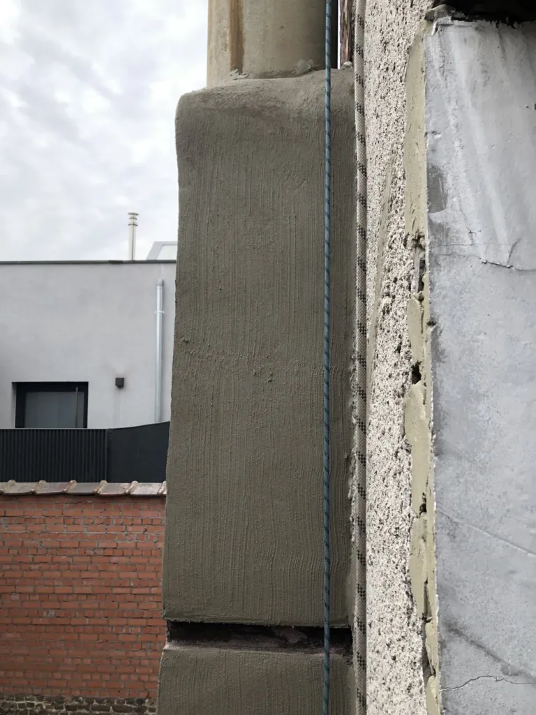 La même maçonnerie après application et lissage de l'enduit, surface régulière le long du conduit