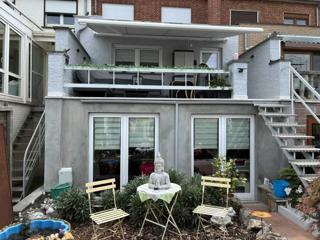 La même façade après application de l'enduit, surface uniforme, terrasse et escalier au-dessus