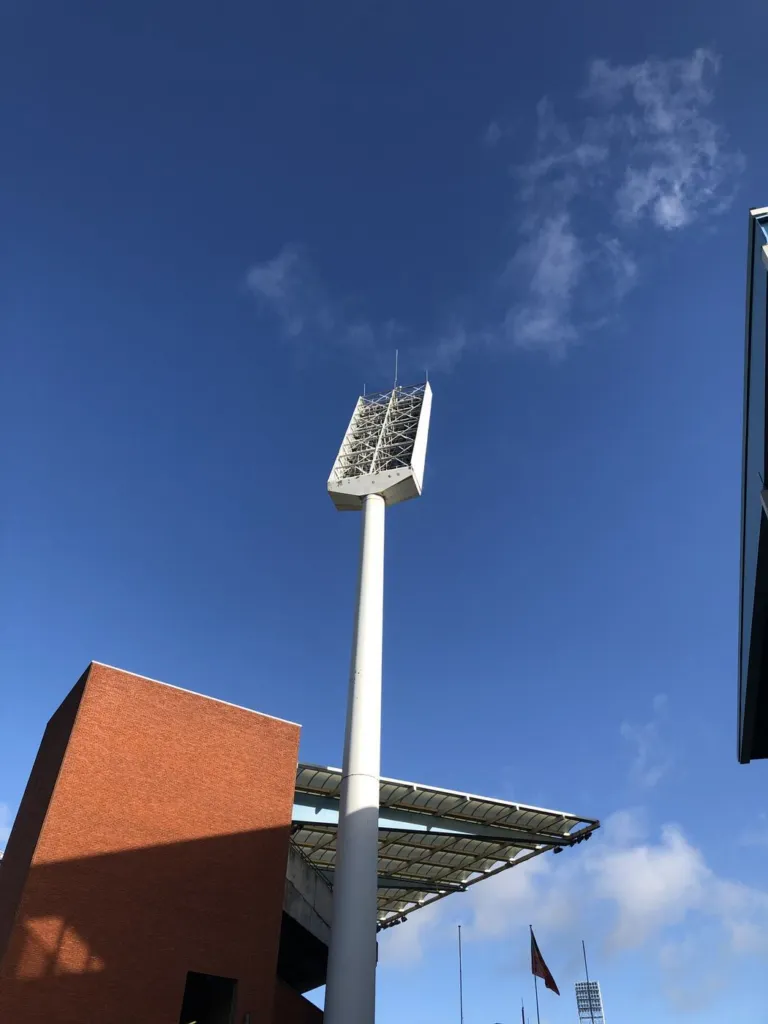 Mât d'éclairage du stade vu depuis le sol, la tête de projecteurs contre le ciel