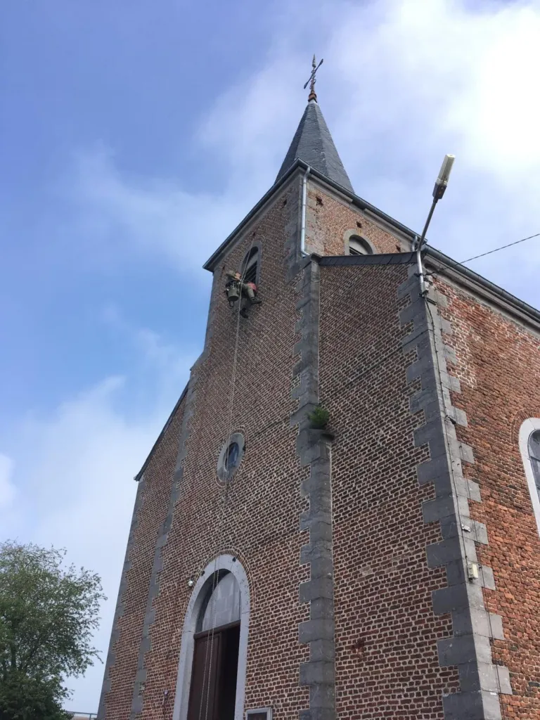 La tour en brique à chaînages de pierre et sa flèche d'ardoise, vue de côté