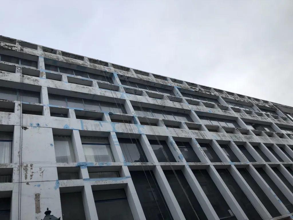 La trame de montants et de traverses en béton vue depuis le sol