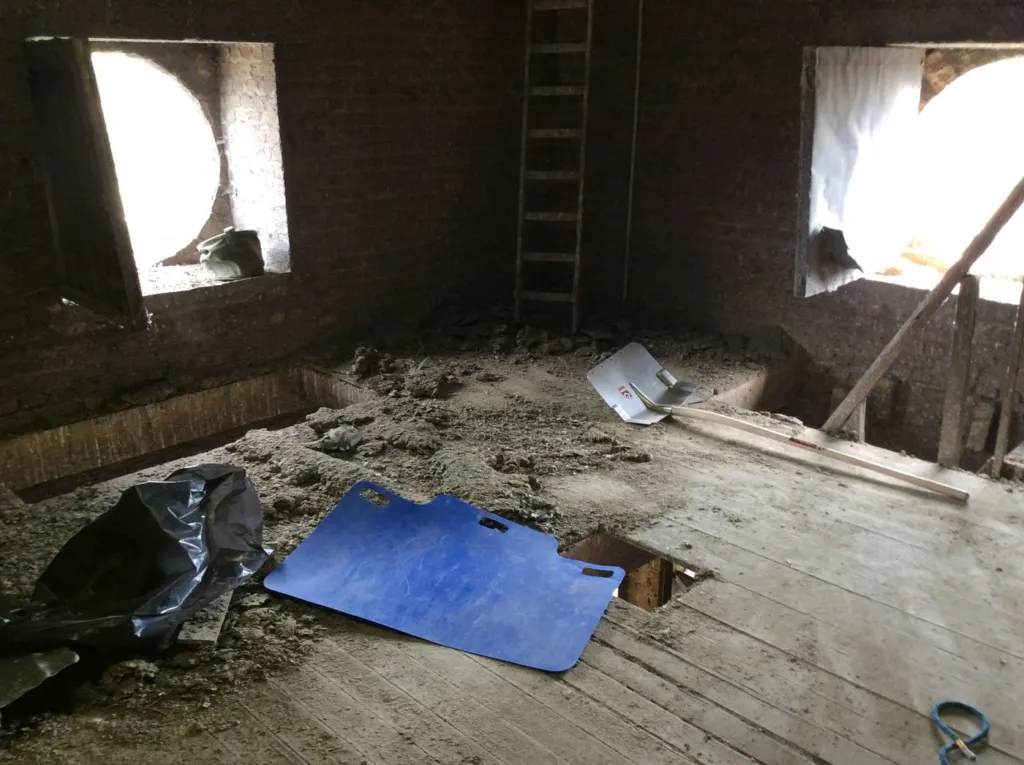 Un plancher du clocher pendant le chantier, dépôts et outils au sol