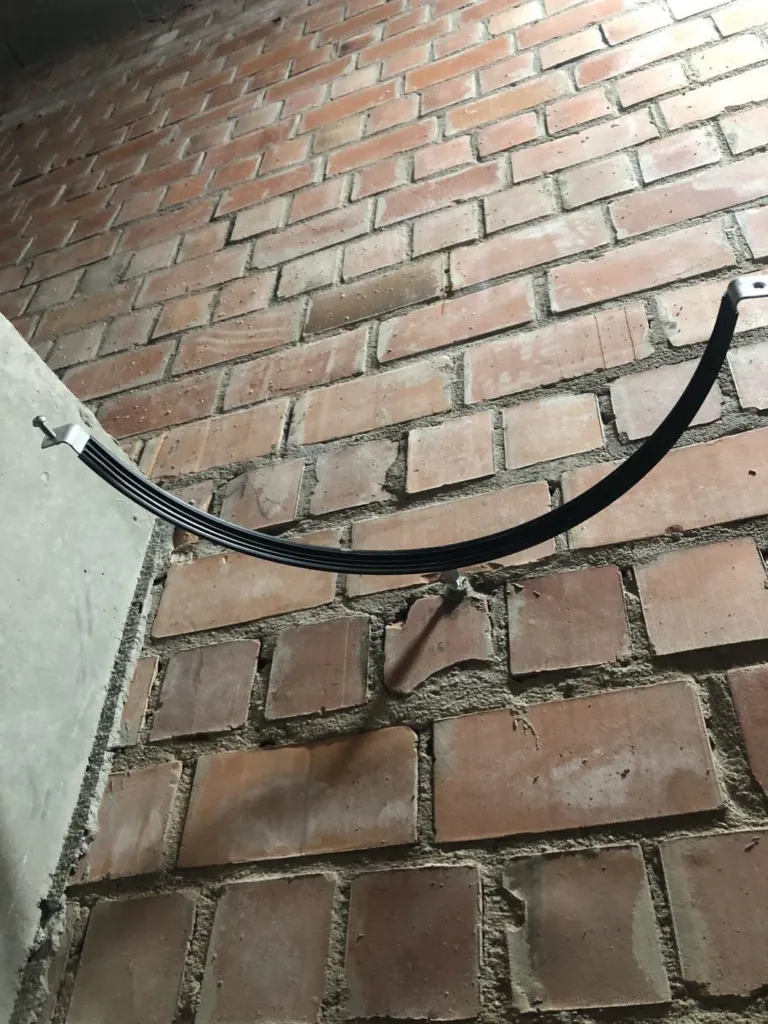 Un support en demi-cercle fixé sur la brique, prêt à recevoir le conduit