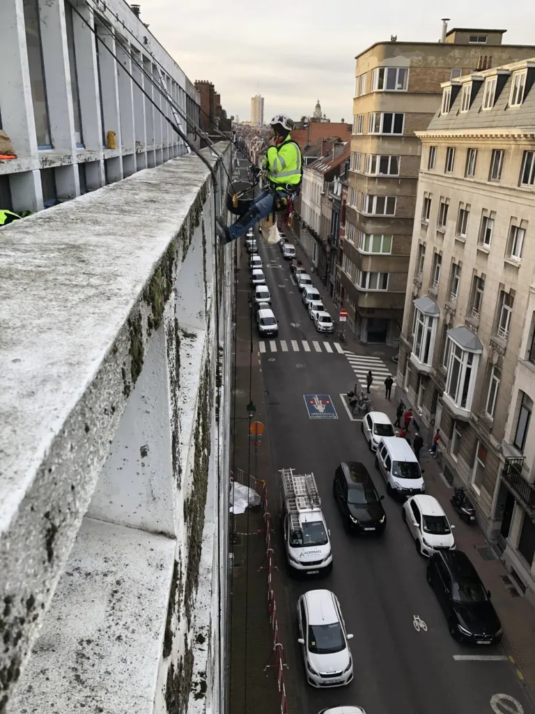 Le cordiste en bordure de façade, vue plongeante sur la rue