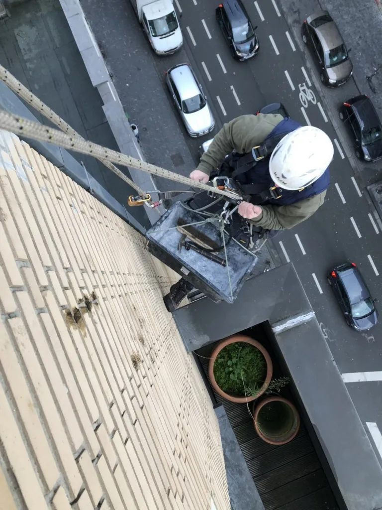Le cordiste en descente avec son bac de récupération, vu d'en haut