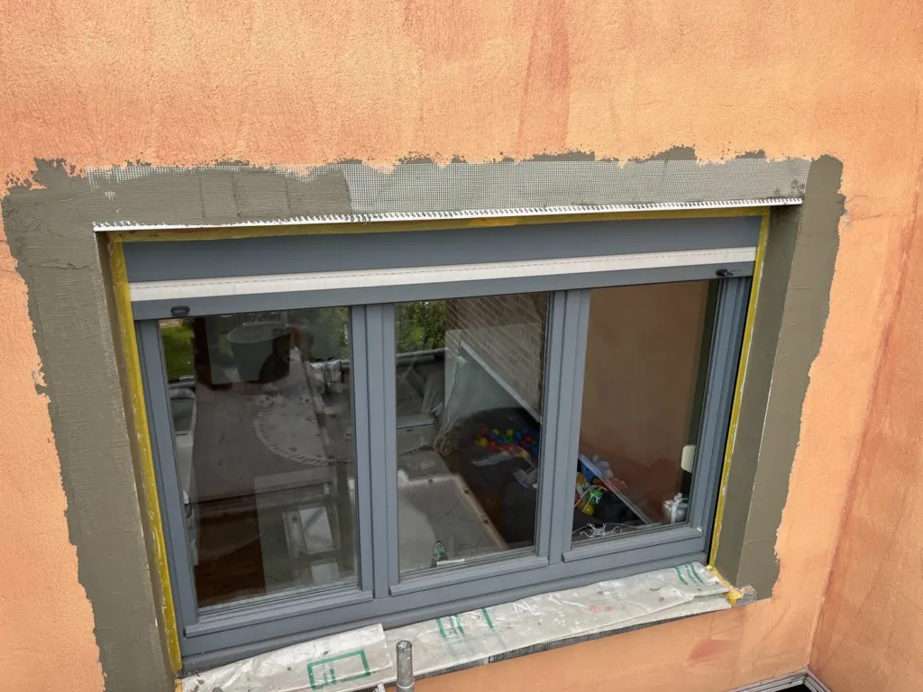 Préparation de l'enduit autour d'une fenêtre, châssis protégé