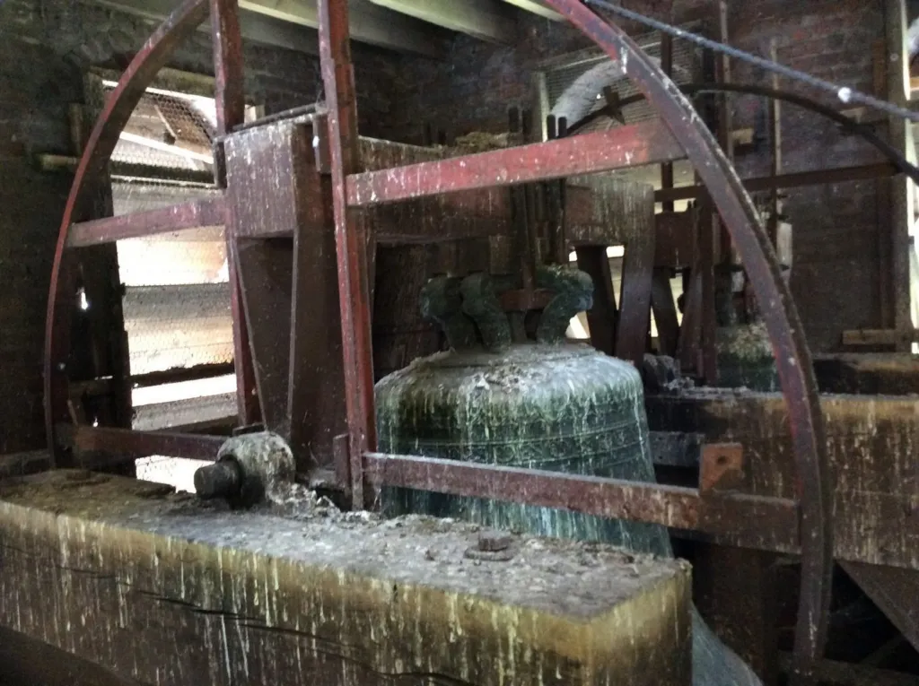 Une cloche et sa structure en bois, couvertes de dépôts