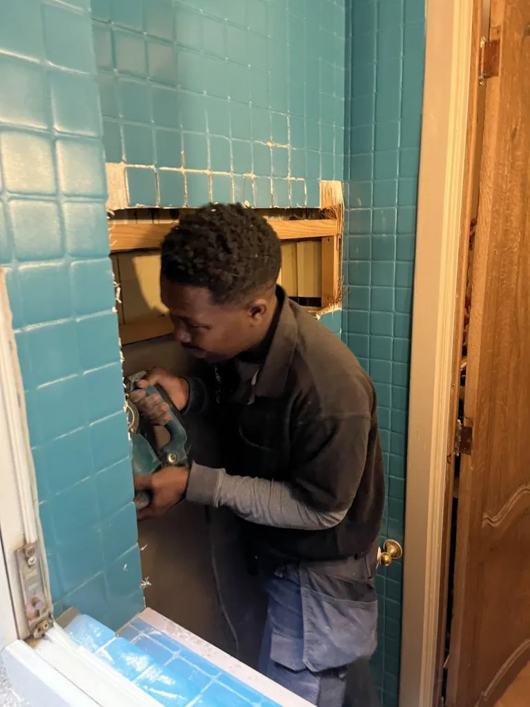 Un intervenant travaille sur le réseau depuis l'intérieur d'une salle de bains