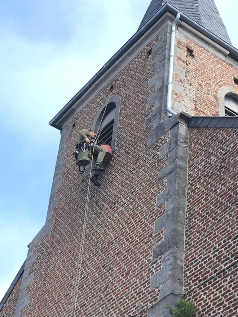 Le cordiste en intervention en partie haute de la tour, sous la flèche