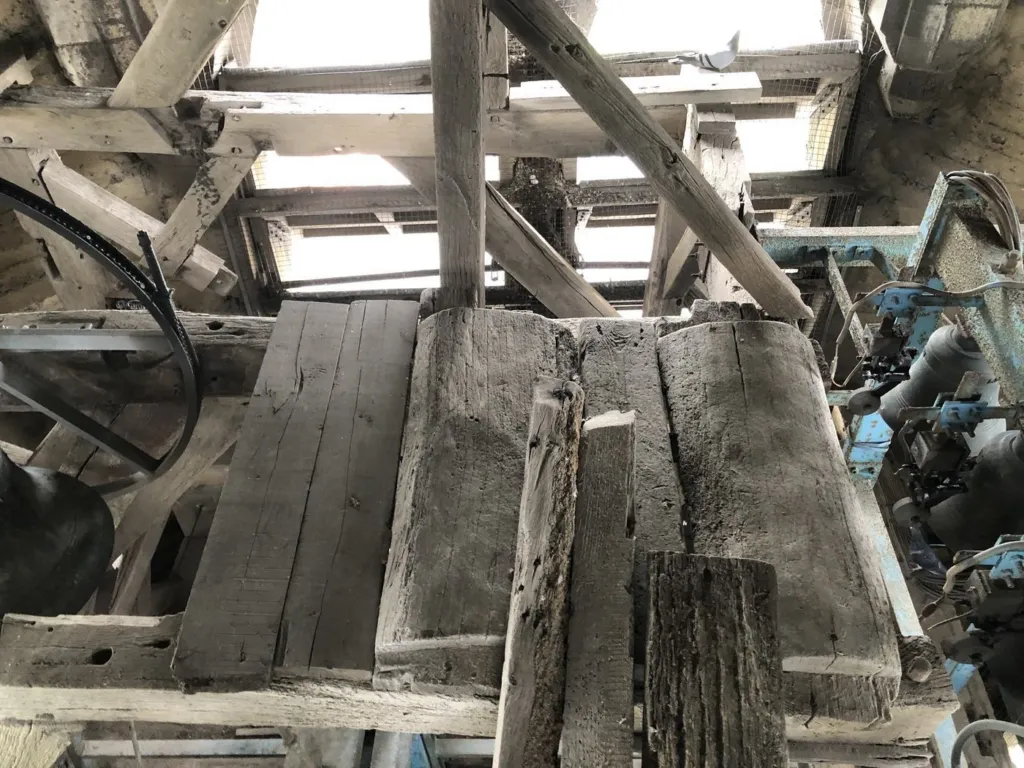 Un plancher en bois et les poutres de la charpente du clocher