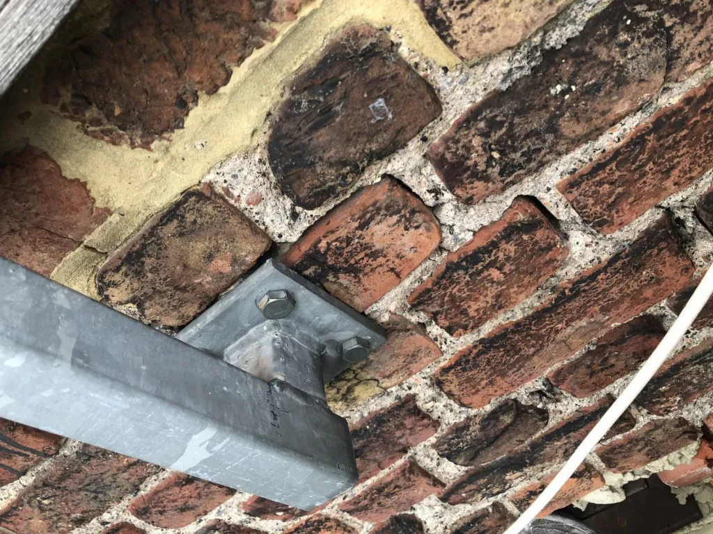 Une platine de renfort boulonnée sur la brique