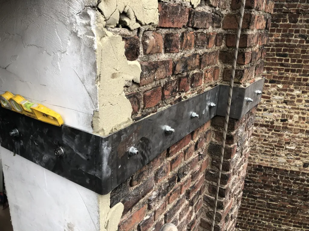 Un renfort métallique posé dans un angle du mur