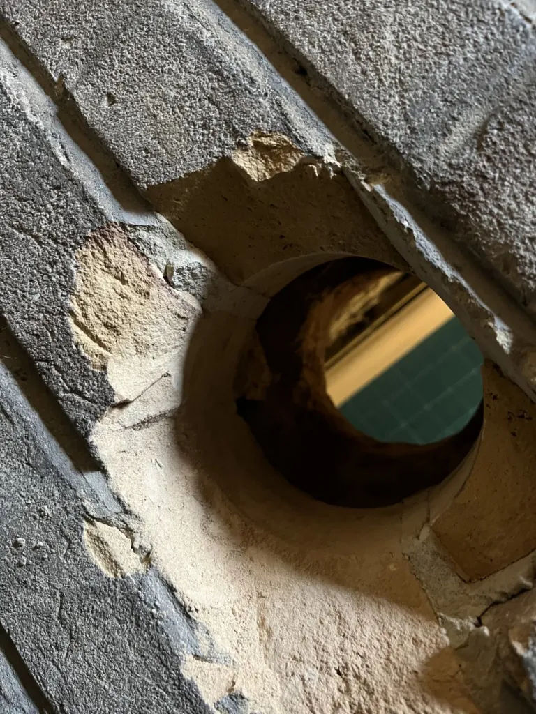 Détail de la traversée du mur par le tube