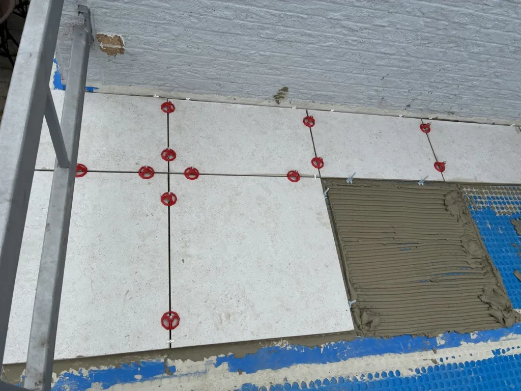 Pose du carrelage sur la natte, carreaux clairs