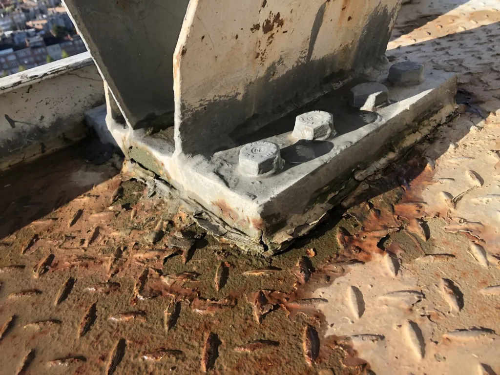Détail d'une platine de fixation avec traces de corrosion