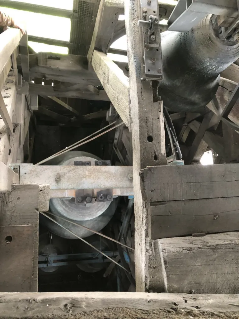 Les cloches entre les poutres de la charpente du clocher