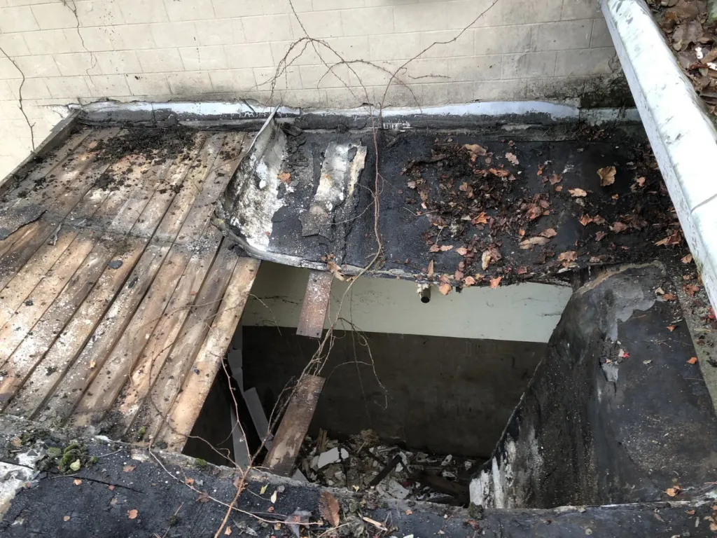 Toiture d'une annexe de château avant intervention, couverture dégradée et éléments disjoints