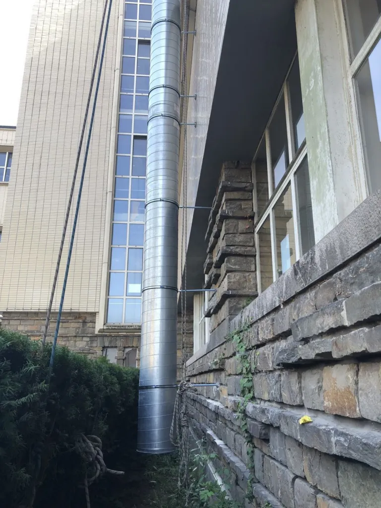 Détail du conduit en pied de façade, avec sa fixation