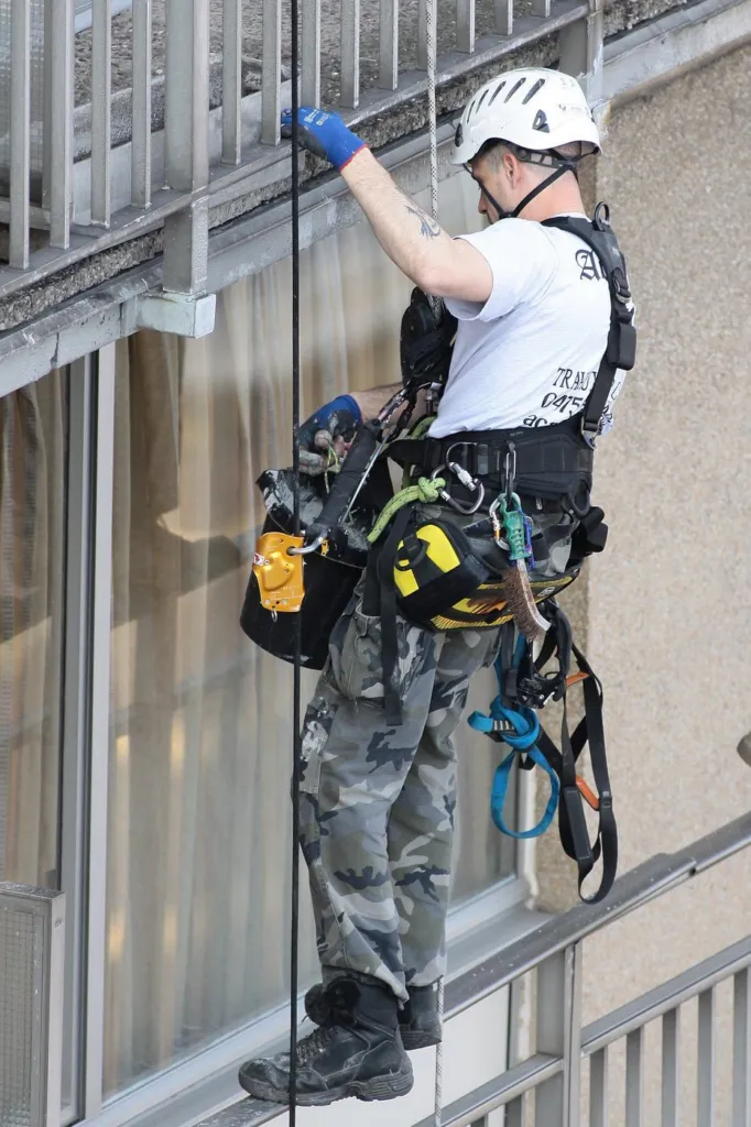 Un cordiste en gros plan pendant une intervention sur la façade