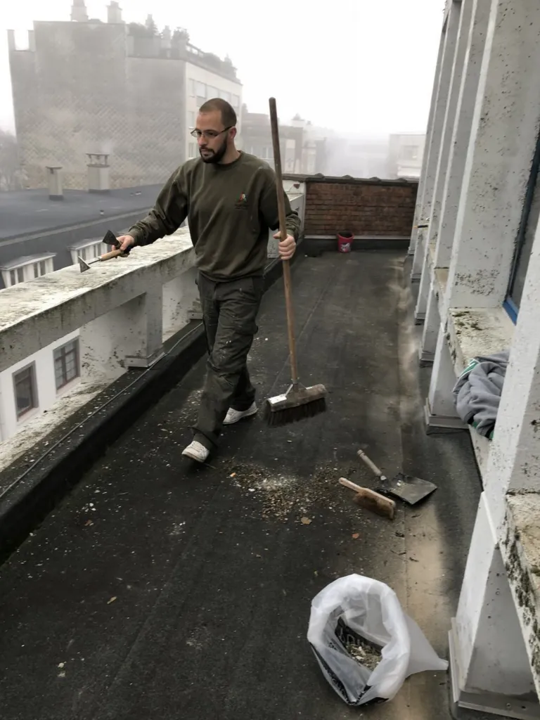Travail depuis la terrasse haute, un intervenant avec des outils de nettoyage