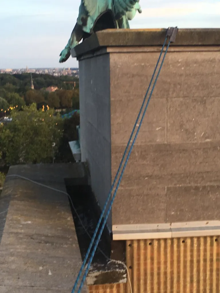 L'installation vue de côté, cordes tendues devant la façade en pierre