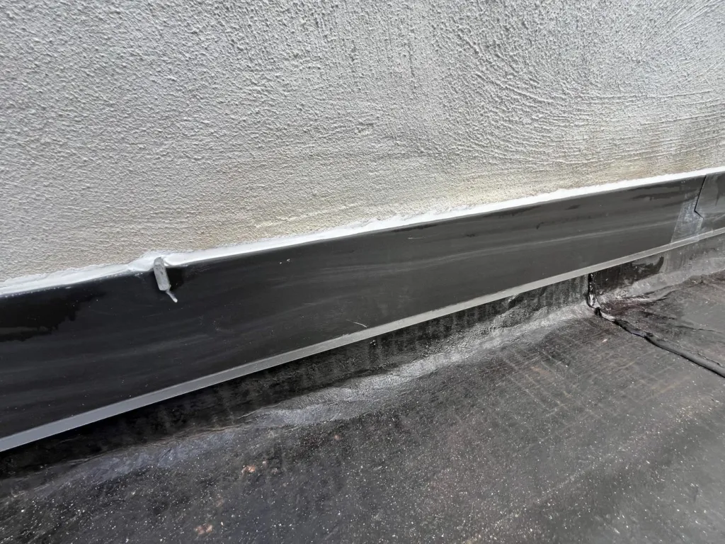 Détail du raccord entre le mur enduit et la toiture