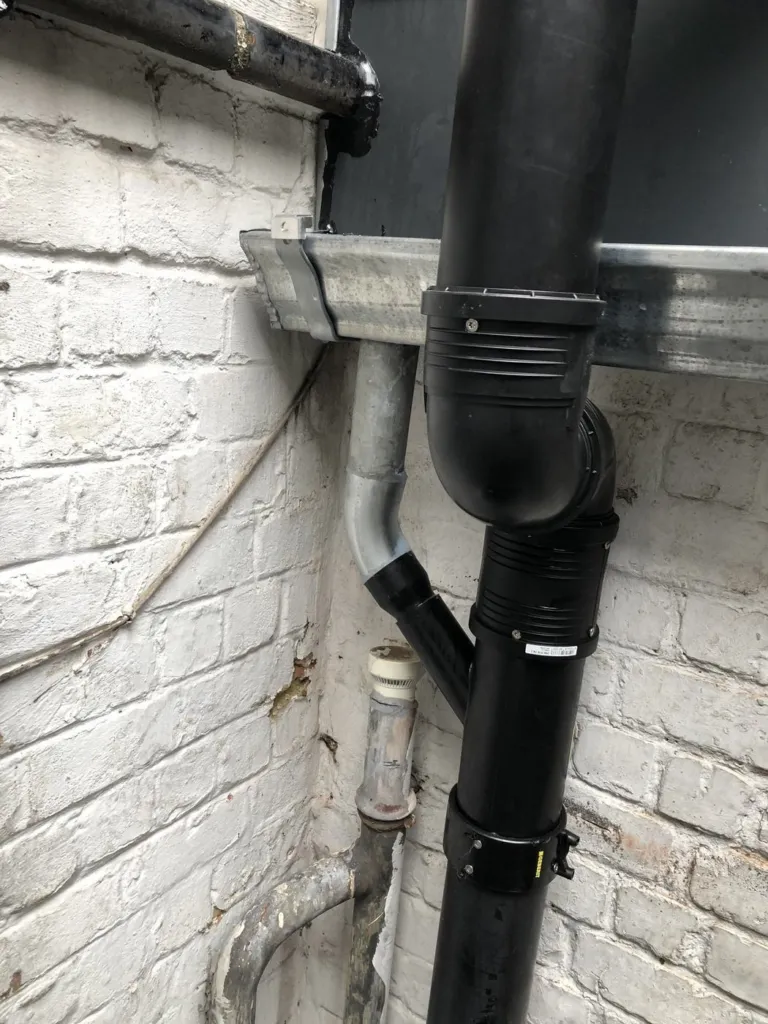 Raccord de la conduite contre le mur, à côté du bardage