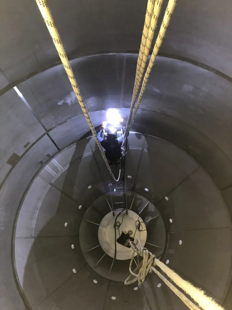 Intérieur du silo éclairé pendant l'intervention, cordes en place